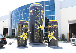 Giant inflatable product replicas designed as oversized Rockstar Energy drink cans for branded marketing displays.