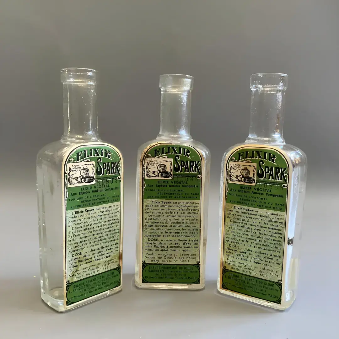 3 bouteilles vides Elixir Spark Grande Pharmacie du Globe, face