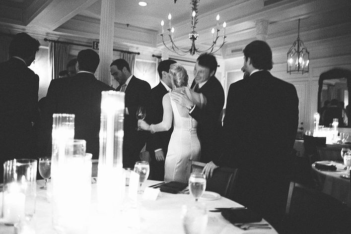 A formal rehearsal dinner for a Charleston wedding at Hall's Chophouse. Photographed on film for an editorial style, the bride wears a slim cut dress with, shear, sleeved top and gold jewelry.