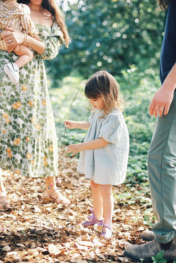 close up portrait of a little girl exploring Hampton Park in Charleston, SC during her family's documentary family photo shoot by Smith Brian. Captured on 35mm Kodak portra 400 film