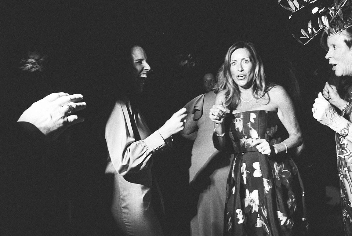 Candid capture of guests on black and white film, laughing, mid dance at a tented Charleston, SC wedding reception. 