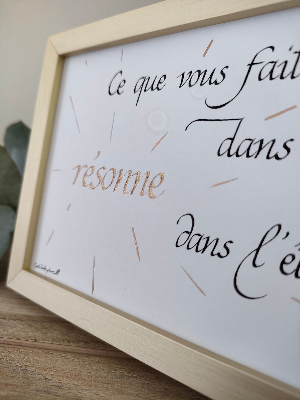 Miniature : Zoom sur le mot "résonne" calligraphié à l'encre dorée.
