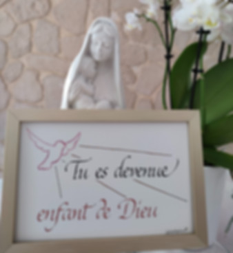 Calligraphie encadrée "Tu es devenue enfant de Dieu" en noir et rose, illustrée d'une colombe rose, idéal pour un cadeau de baptême.