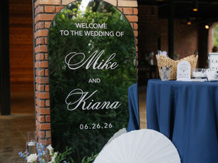Elegant wedding welcome display featuring a custom mirrored sign, white parasol, and blue-and-white floral arrangements at a luxury wedding reception.
