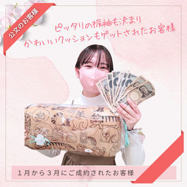 大きな猫のイラストが描かれたクッションと、現金つかみどりのお札を両手に持って嬉しそうな表情の振袖ご成約のお嬢様。