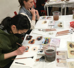 Assortment of watercolor paints, brushes, and paper prepared for the Watercolor 101 class