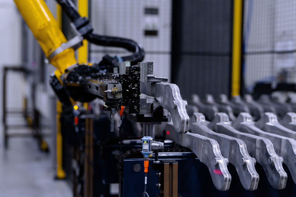 The FANUC robot lifts a raw forging from the conveyor. CNC Solutions’ automated cell eliminates ergonomic challenges and misload risks for these 12.5-pound aluminum parts. 