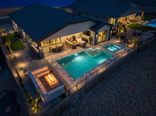Modern desert home backyard with pool and fire pit at night