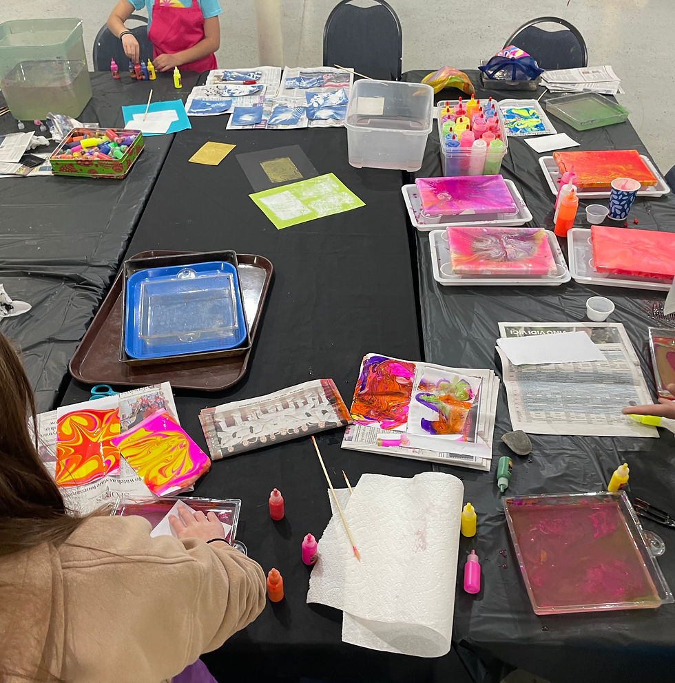 Students working independently in D.I.P Club (water marbling, tempera pouring, sun prints, and block printing stations)