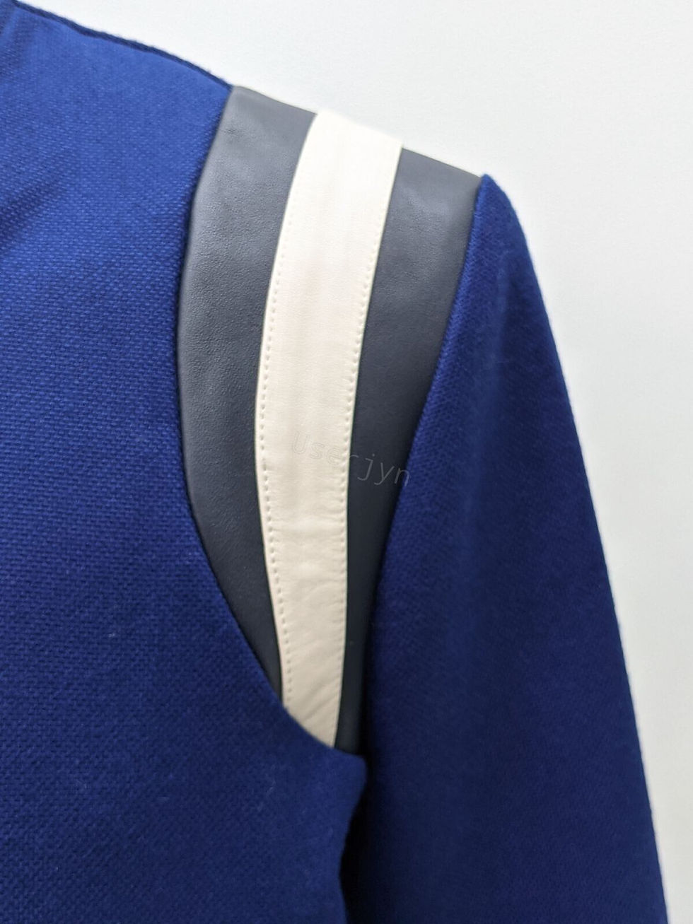 縮圖：Blue jacket with leather patches, visible text 'by' on shoulder, Userjyn