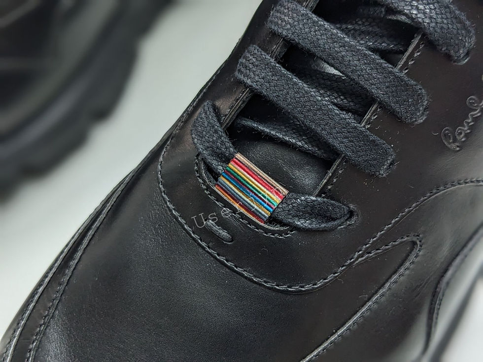 Black leather shoe, U.S.P. logo, vibrant rainbow striped lace tag detail.