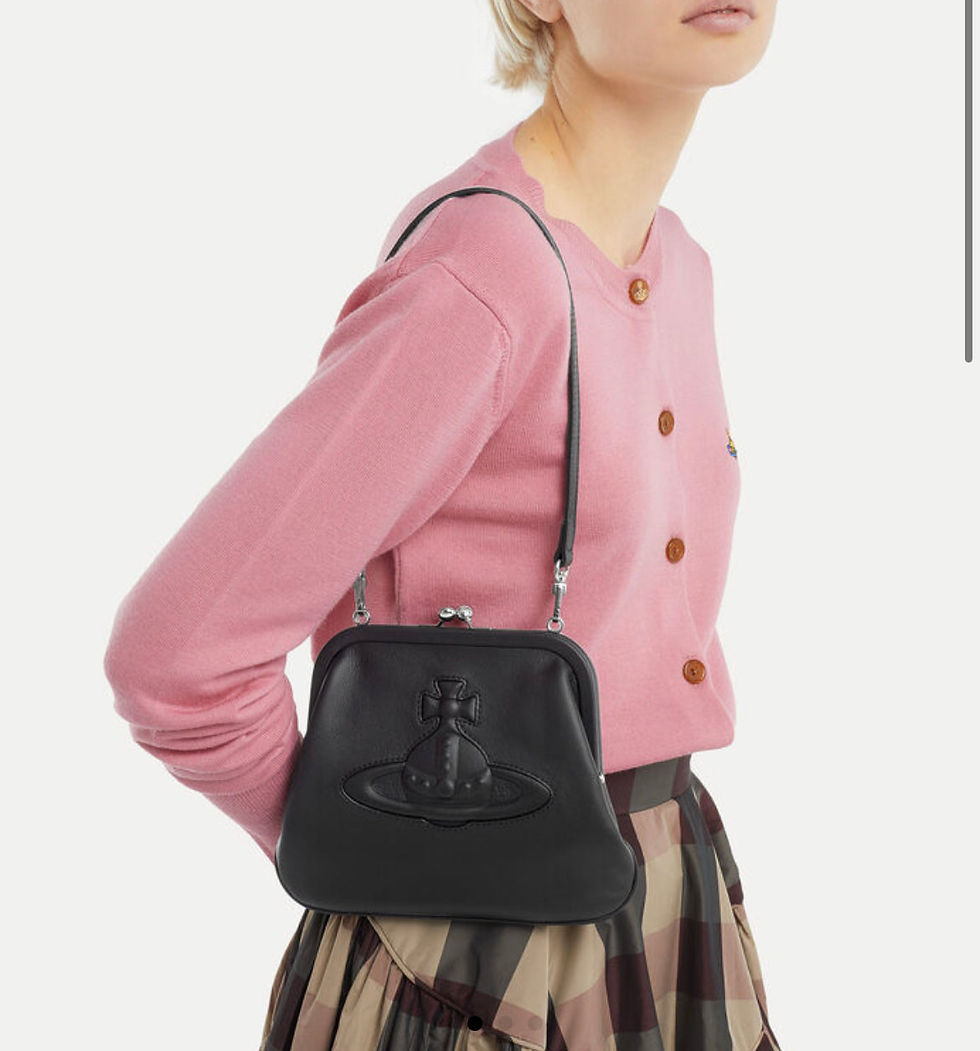 Thumbnail: Woman with Vivienne Westwood black purse and pink cardigan Userjyn fashion style.