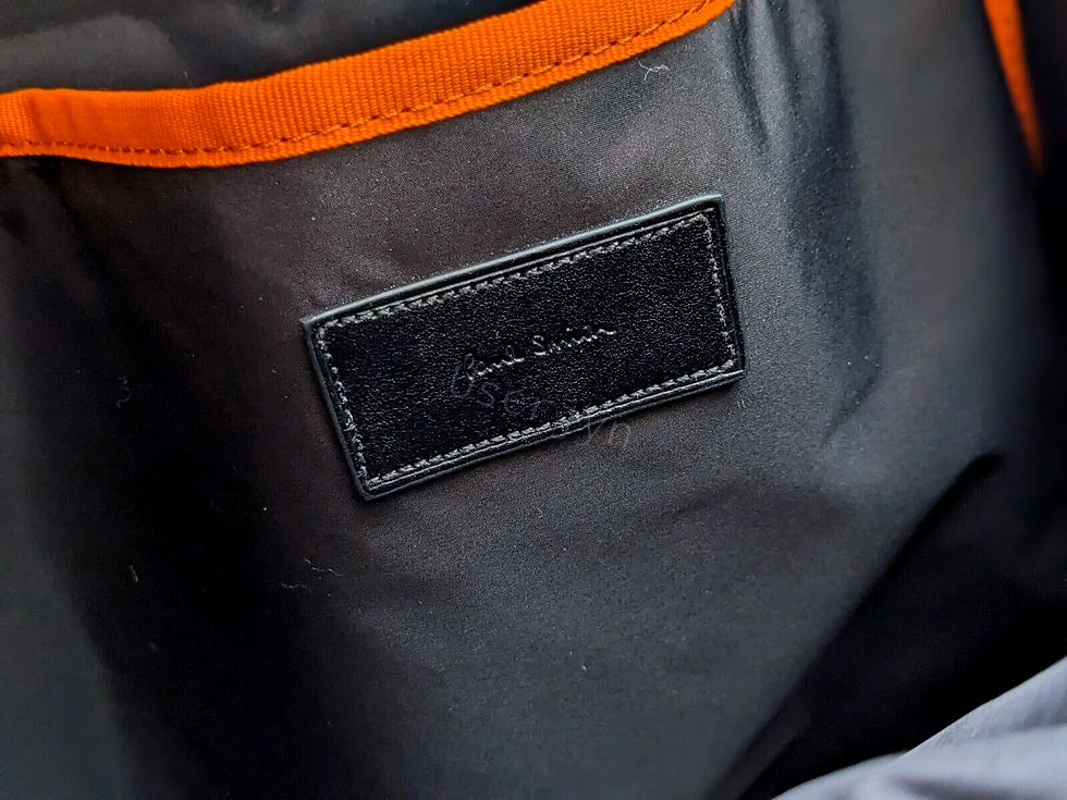 縮圖：Paul Smith logo on a black bag, with orange lining, a luxury holdall.