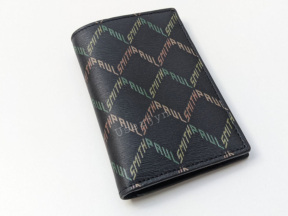 Black leather Paul Smith wallet, colorful repeating text pattern.