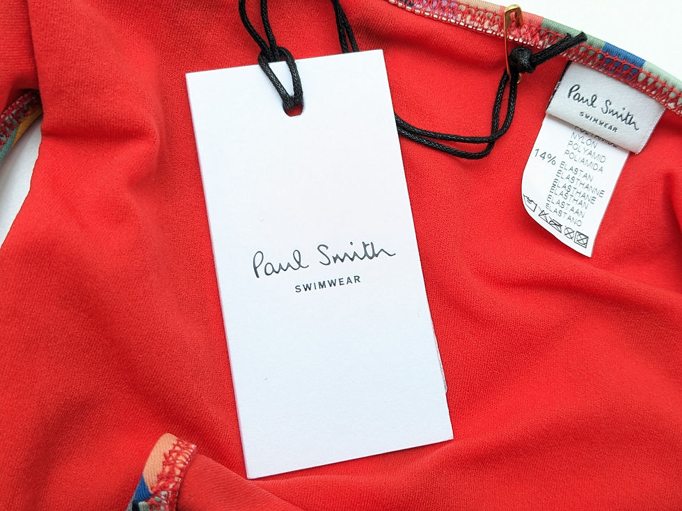 Thumbnail: Paul Smith Swimwear tag on a red garment.