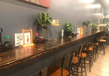Long dark brown bar table made from pine wood.
