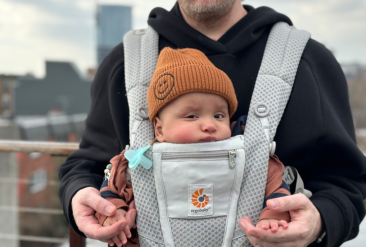 Infant being worn in a baby carrier
