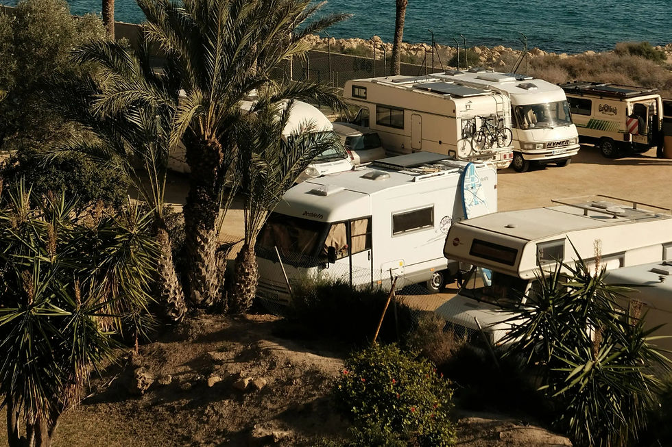 Camper in vista dall'alto parcheggiati in riva al mare