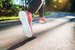 Female runner jogging down an outdoor tr