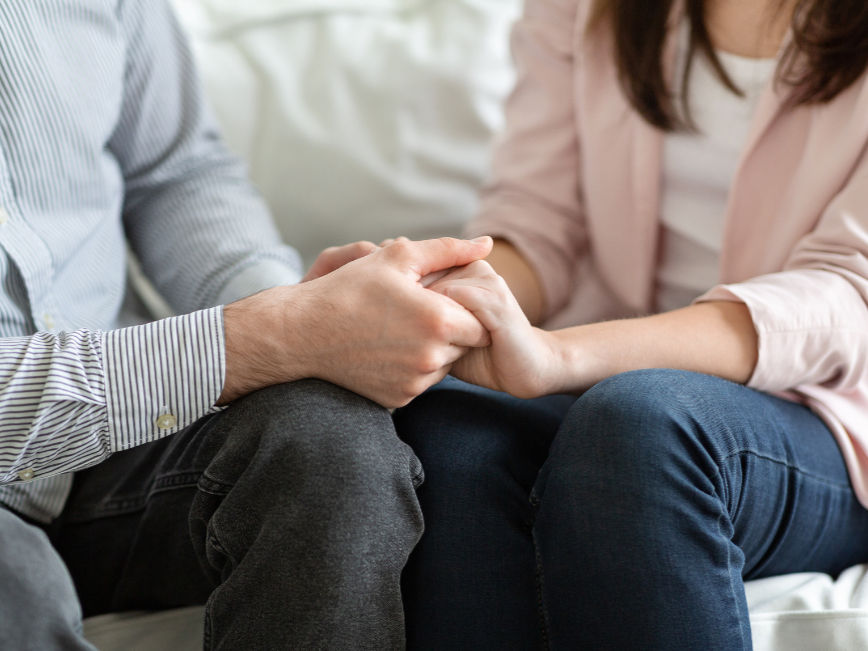 A young couple holding hands, overcoming marriage relationship troubles through coaching with David Roper.
