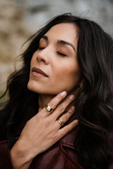 Woman with closed eyes wearing gold rings