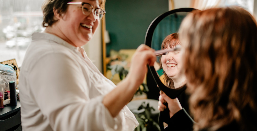 Katie-Laine Thornton demonstrating makeup techniques during a private Nashville makeup lesson while a client follows along with a hand mirror.
