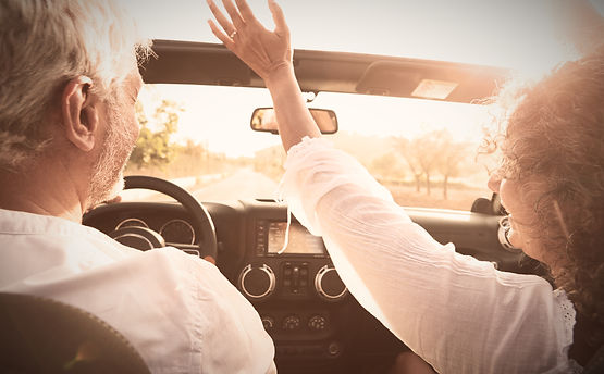 Mature Couple Driving Along Country Road In Open Top Car_edited.jpg