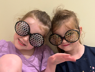 Children looking through bee eyed glasses