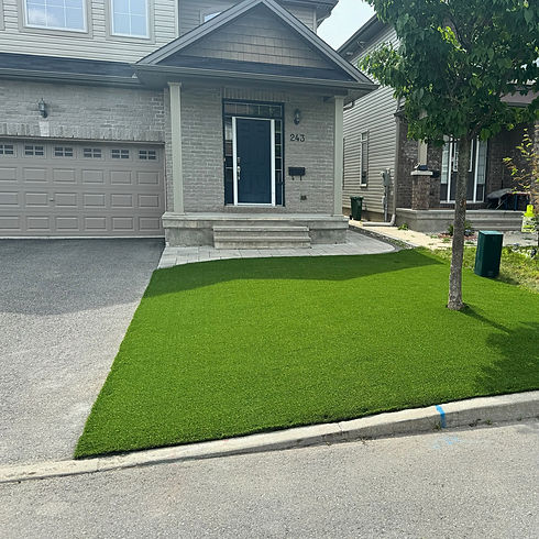 Front-yard artificial turf installation by LevelScape, paired with interlock driveway