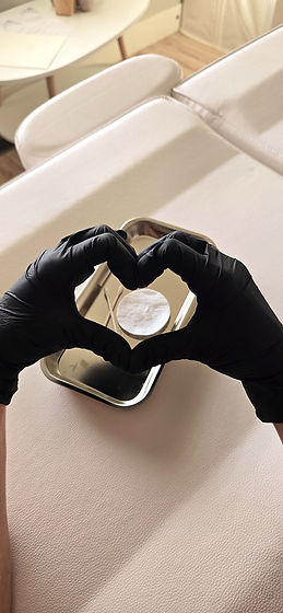 Gloved hands forming a heart over a sterile tray in a clean electrolysis treatment space