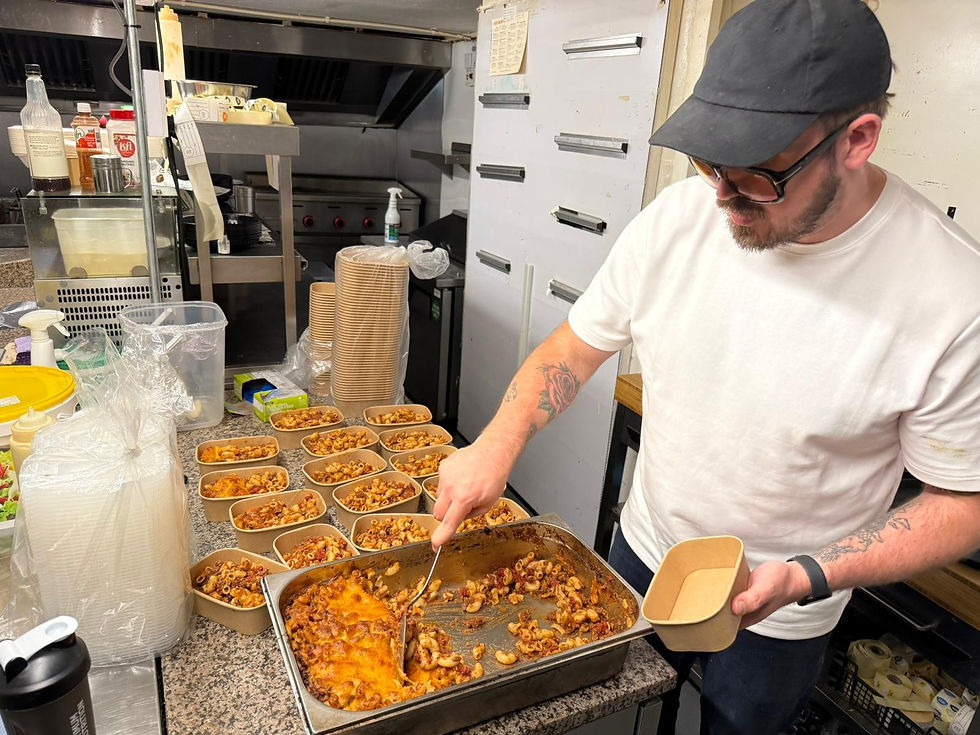 Tom Cook portioning out a Cheesy Bolognese Bake