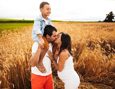 Une femme enceinte avec son conjoint et leurs garçon