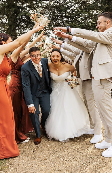 Des mariés qui avance sous une hai d'honneur.
