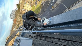 A professional roofer painting a roof
