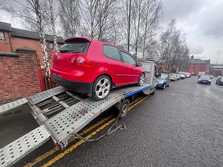 A red car on a towing truck