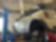 A car lifted on a hoist in a garage with the front wheel removed