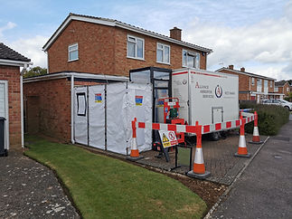 A house undergoing asbestos removal with proper equipment and containment unit