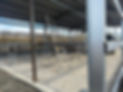 A construction site with a ladder leaning against a steel frame