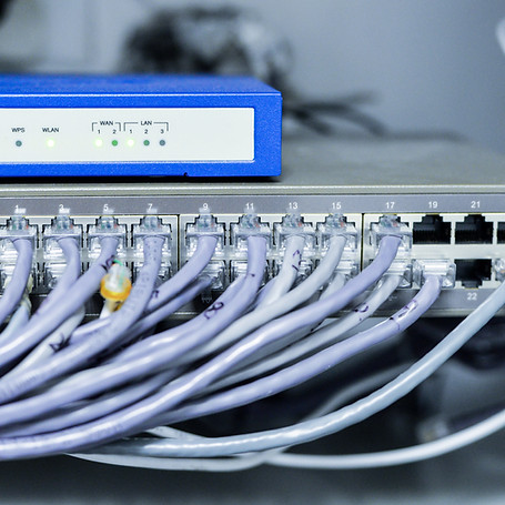 A blue and white network switch with several connected wires