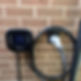 An Ohme electric vehicle charger is mounted on a brick wall