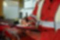 A close-up of a person in an orange safety jacket writing on a clipboard with a pen
