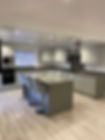 Modern kitchen with sleek grey cabinetry, a large island with four padded chairs