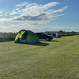 Green tent and cars on a camping field