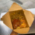 A takeout box filled with rice, tender curry meat, fried chicken with sauce, and grilled fish, held in a hand