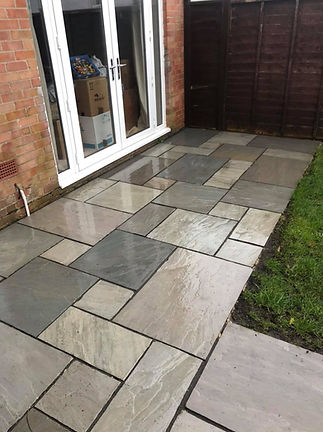 Wet stone patio with rectangular tiles in shades of grey and beige