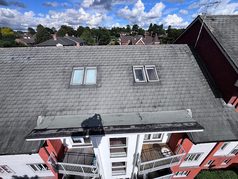 Aerial view of a building with a grey tiled roof, featuring skylight
