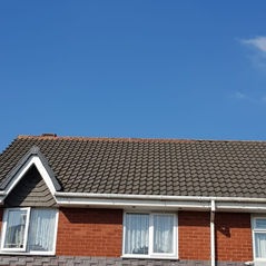 A gable-roofed brick house with white-framed windows