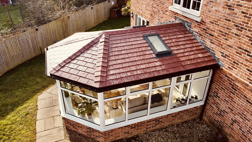 Aerial view of a brick house with a red-tiled conservatory roof and skylight