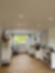 Bright and organized art studio with herringbone flooring, large window and ceiling bulbs