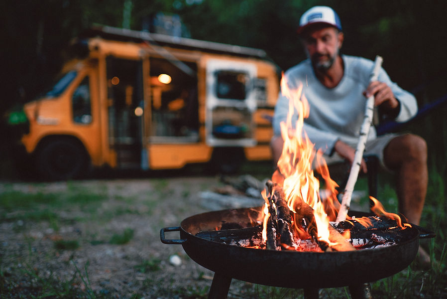 A crackling campfire burns in a metal fire pit outdoors